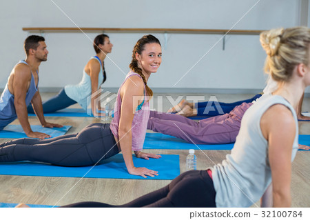 Group of people performing yoga 32100784