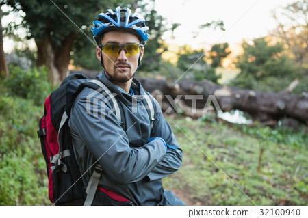 Portrait of male mountain biker with arms crossed in the forest 32100940