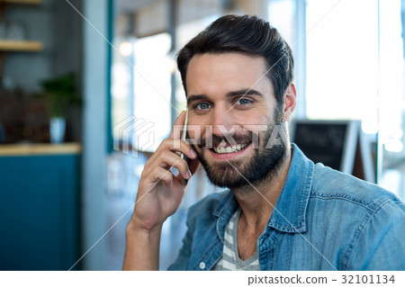 Smiling man talking on mobile phone 32101134