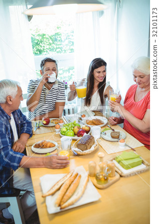Happy couple having breakfast with their parents 32101173