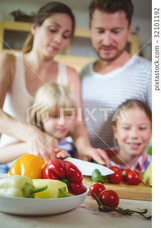 Family chopping vegetables in the kitchen Family chopping vegetables in the kitchen 32101192