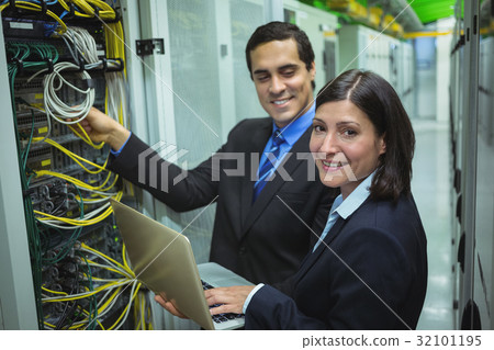 Technicians using laptop while analyzing server Technicians using laptop while analyzing server 32101195