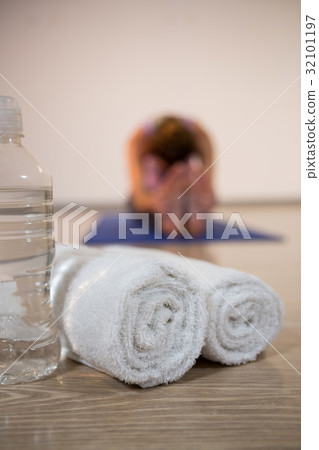 Rolled towels and water bottle in fitness studio 32101197