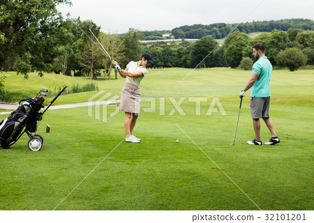 Male instructor assisting woman in learning golf 32101201