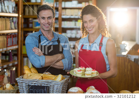 Portrait of smiling staff standing at bakery counter Portrait of smiling staff standing at bakery counter 32101212
