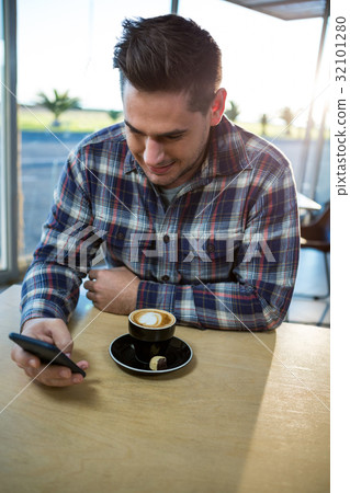 Man using his mobile phone in the coffee shop Man using his mobile phone in the coffee shop 32101280