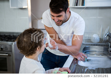Son helping father in washing utensils Son helping father in washing utensils 32101281