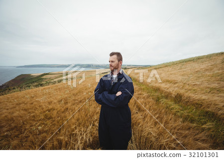 Farmer standing with arms crossed in the field Farmer standing with arms crossed in the field 32101301