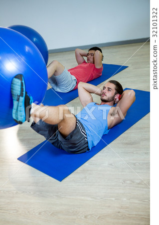 Men exercising with exercise ball 32101322