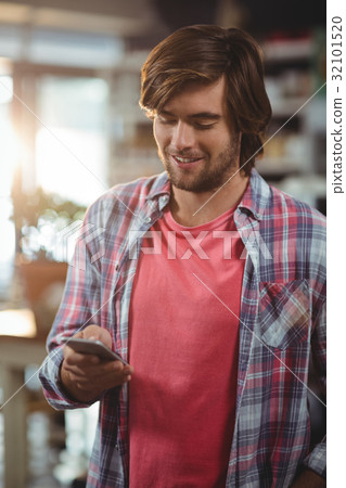 Smiling man using mobile phone Smiling man using mobile phone 32101520