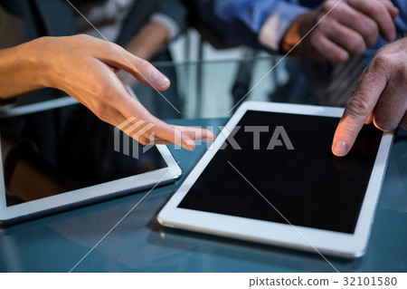Businessman discussing with colleague over digital tablet 32101580
