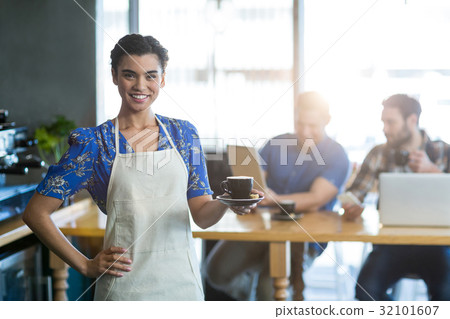 Portrait of waitress holding cup of coffee 32101607