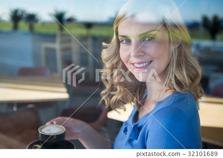 Smiling woman holding a coffee cup Smiling woman holding a coffee cup 32101689