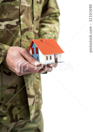 Mid section of soldier holding a model home Mid section of soldier holding a model home 32101690