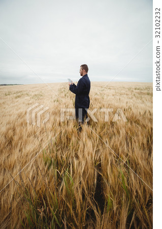 Farmer using digital tablet in the field 32102232
