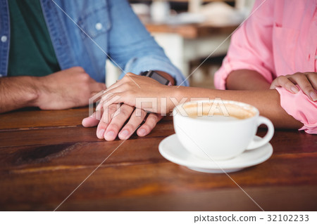 Mid-section of couple holding hands 32102233