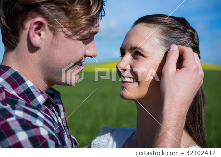 Romantic couple looking at each other in field 32102412