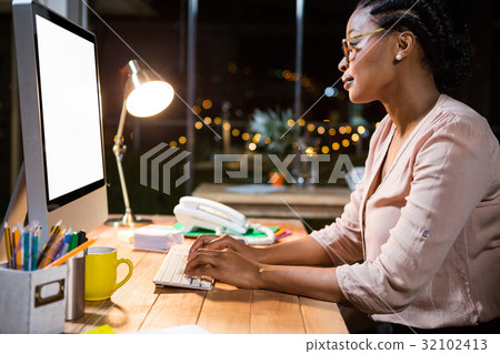 Businesswoman working on computer at her desk 32102413