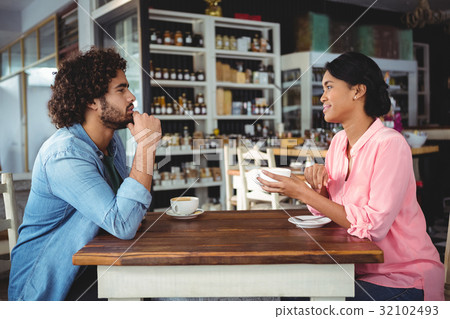 Couple interacting with each other while having coffee Couple interacting with each other while having coffee 32102493