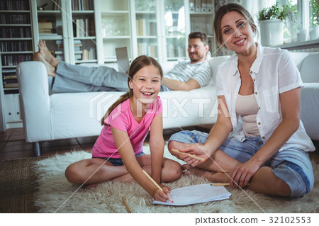 Mother and daughter sitting on the floor and drawing 32102553