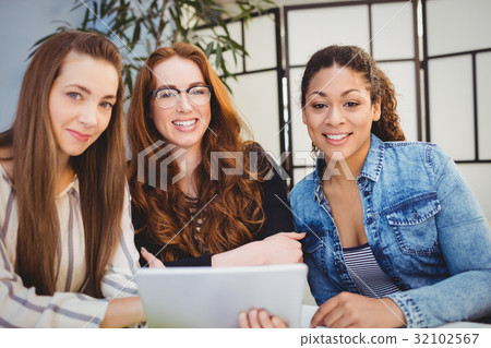 Smiling creative business people with digital tablet Smiling creative business people with digital tablet 32102567