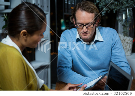 Business executives discussing over digital tablet Business executives discussing over digital tablet 32102569