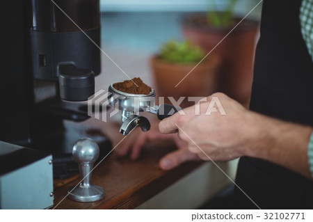 Waiter holding portafilter filled with ground coffee Waiter holding portafilter filled with ground coffee 32102771