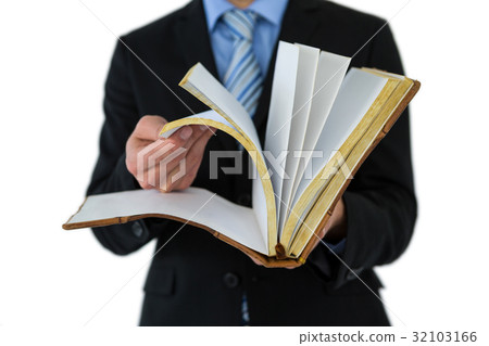 Mid section of businessman flips through the pages of a book Mid section of businessman flips through the pages of a book 32103166