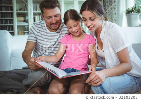 Parents and daughter looking at photo album 32103205