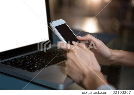 Woman text messaging on mobile phone in the office 32103207