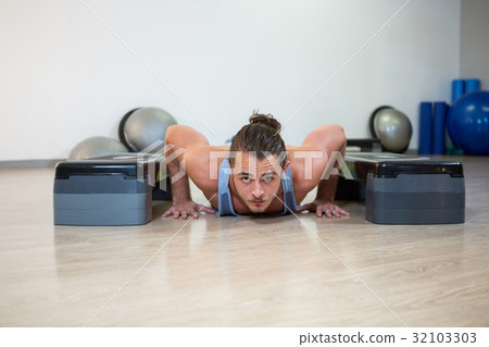 Portrait of man doing aerobic exercise on stepper 32103303