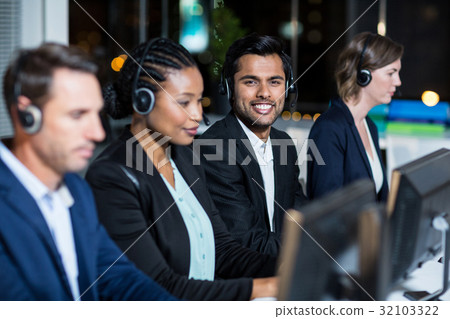 Colleagues with headsets using computer at office 32103322