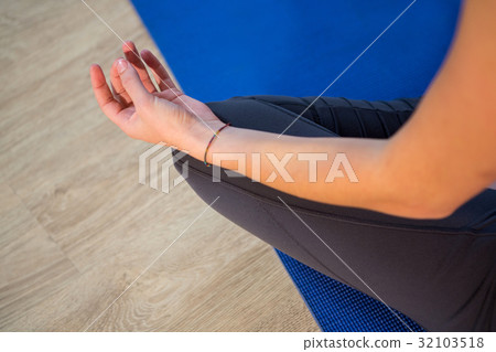 Mid section of woman doing yoga on exercise mat Mid section of woman doing yoga on exercise mat 32103518