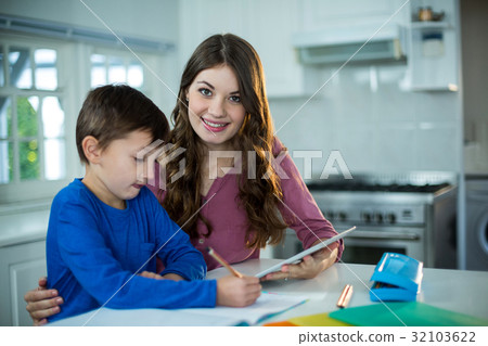 Mother helping her son with homework 32103622