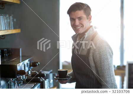 Portrait of waiter holding cup of coffee 32103706