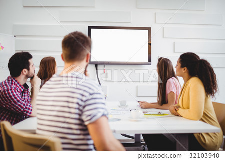 Executives watching at television during training in creative office 32103940