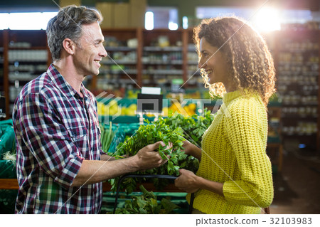 Happy couple buying vegetables in organic section 32103983