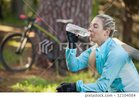Female mountain biker drinking water 32104084