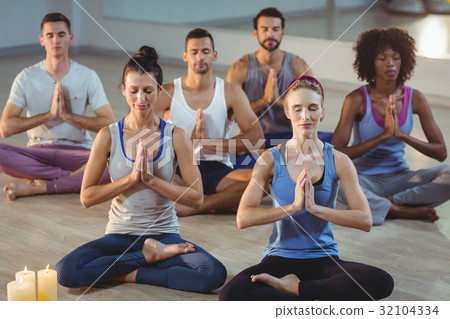 Group of people performing yoga 32104334