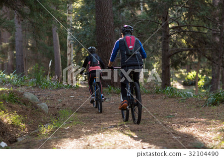 Biker couple cycling in countryside Biker couple cycling in countryside 32104490