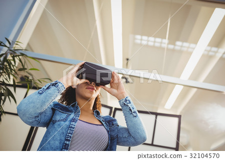 Low angle view of businesswoman enjoying virtual reality headset at office 32104570