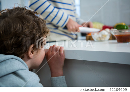 Boy looking while father chopping vegetables 32104609