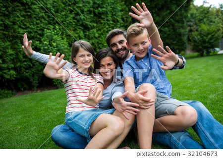 Happy family sitting on grass in park on a sunny day 32104673