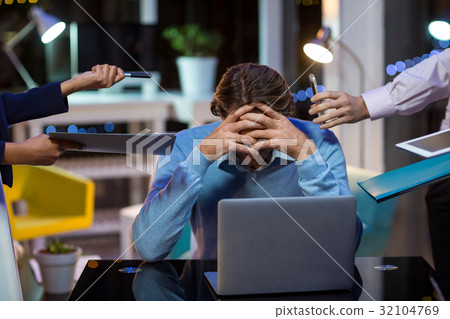 Frustrated businessman sitting in office Frustrated businessman sitting in office 32104769