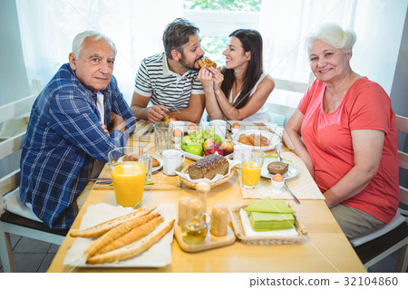 Happy couple having breakfast with their parents Happy couple having breakfast with their parents 32104860