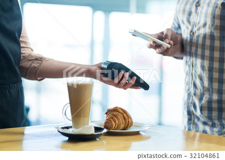 Man paying bill through smartphone using NFC technology Man paying bill through smartphone using NFC technology 32104861