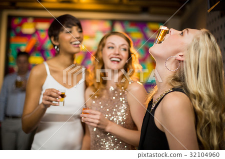 Woman balancing a shot glass on her mouth Woman balancing a shot glass on her mouth 32104960