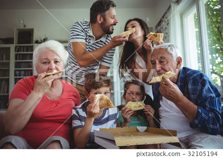 Multi-generation family having pizza together 32105194