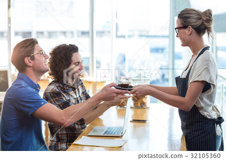 Waitress serving a cup of coffee to customer 32105360