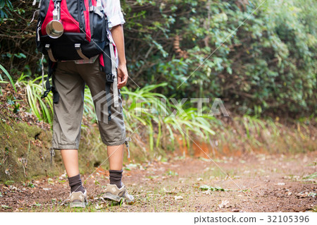 Female hiker walking in forest with backpack 32105396